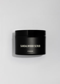 Sandalwood Erogenous Body Scrub in a black jar on a clean light surface