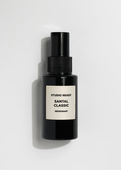 Black spray deodorant bottle with beige label reading Santal Classic Studio Ready