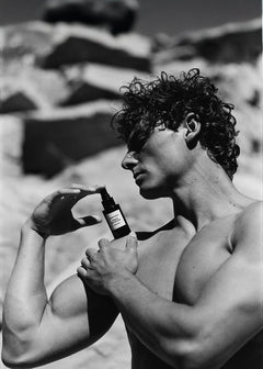 Monochrome photo of a shirtless man applying Force of Nature spray deodorant.